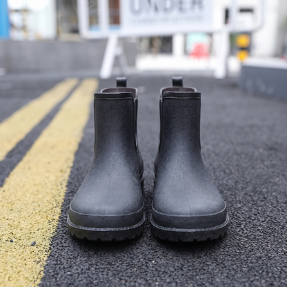 Schwarze Gummistiefel auf Asphalt, Nahaufnahme von hinten fotografiert | Chaps Herrenmode