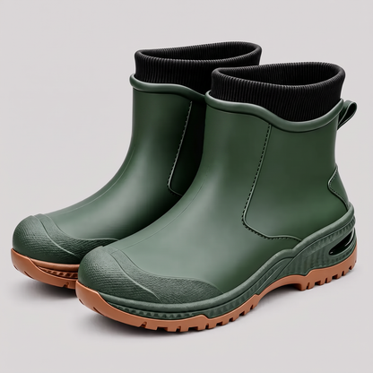 Grüne Gummistiefel mit schwarzen Strickbündchen und brauner Profilsohle, Studioaufnahme.