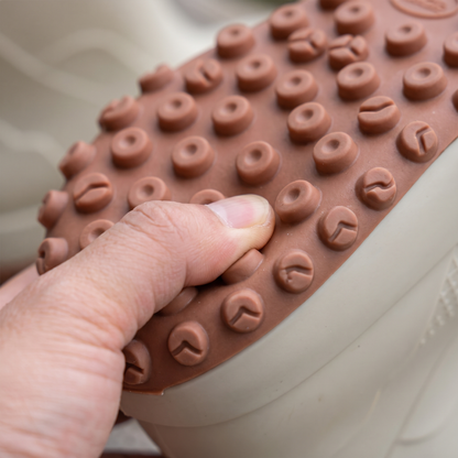 Beiger Gummistiefel mit brauner Profilsohle, Finger drückt auf Noppenstruktur | Chaps Herrenmode