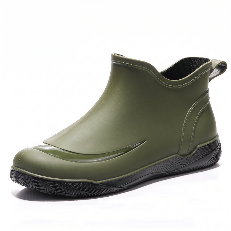 Grüner kurzer Gummistiefel mit schwarzer Profilsohle und Zuglasche, Seitenansicht