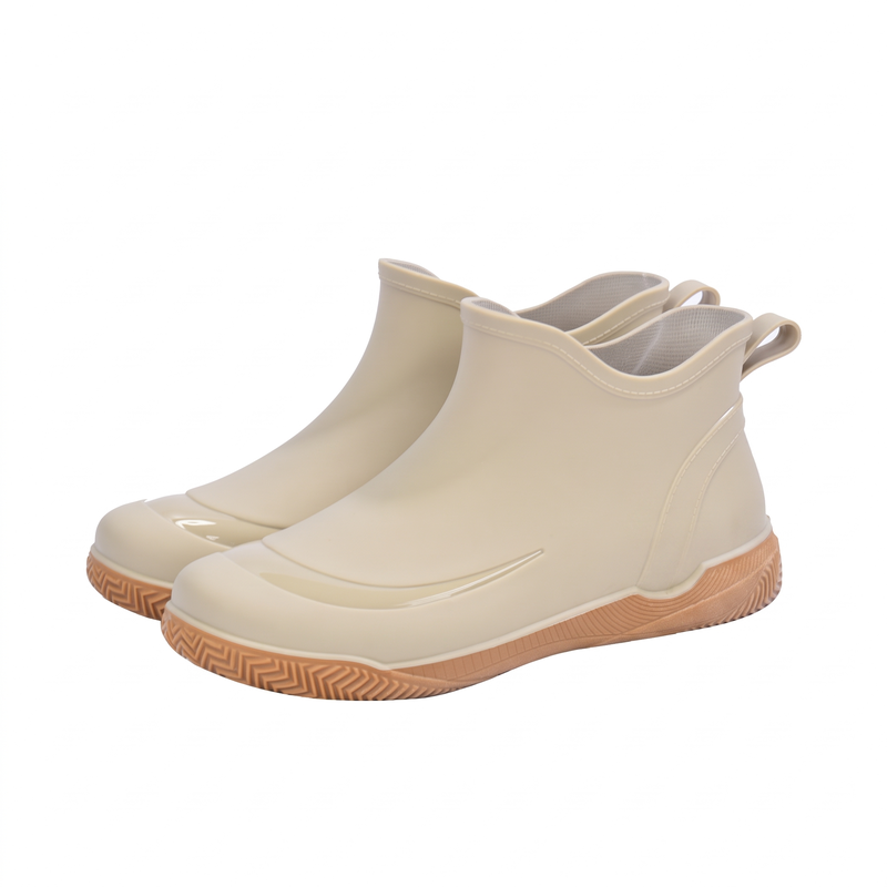 Ein Paar beige kurze Gummistiefel mit hellbrauner Profilsohle