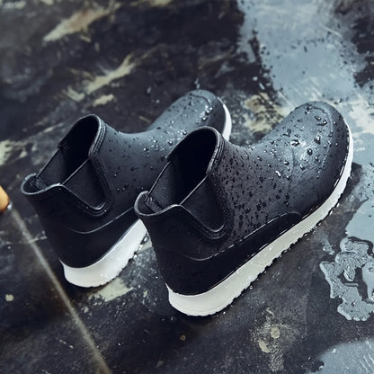 Schwarze Chelsea Regenstiefel mit weißer Sohle, nass, auf dunklem Untergrund | Chaps Herrenmode