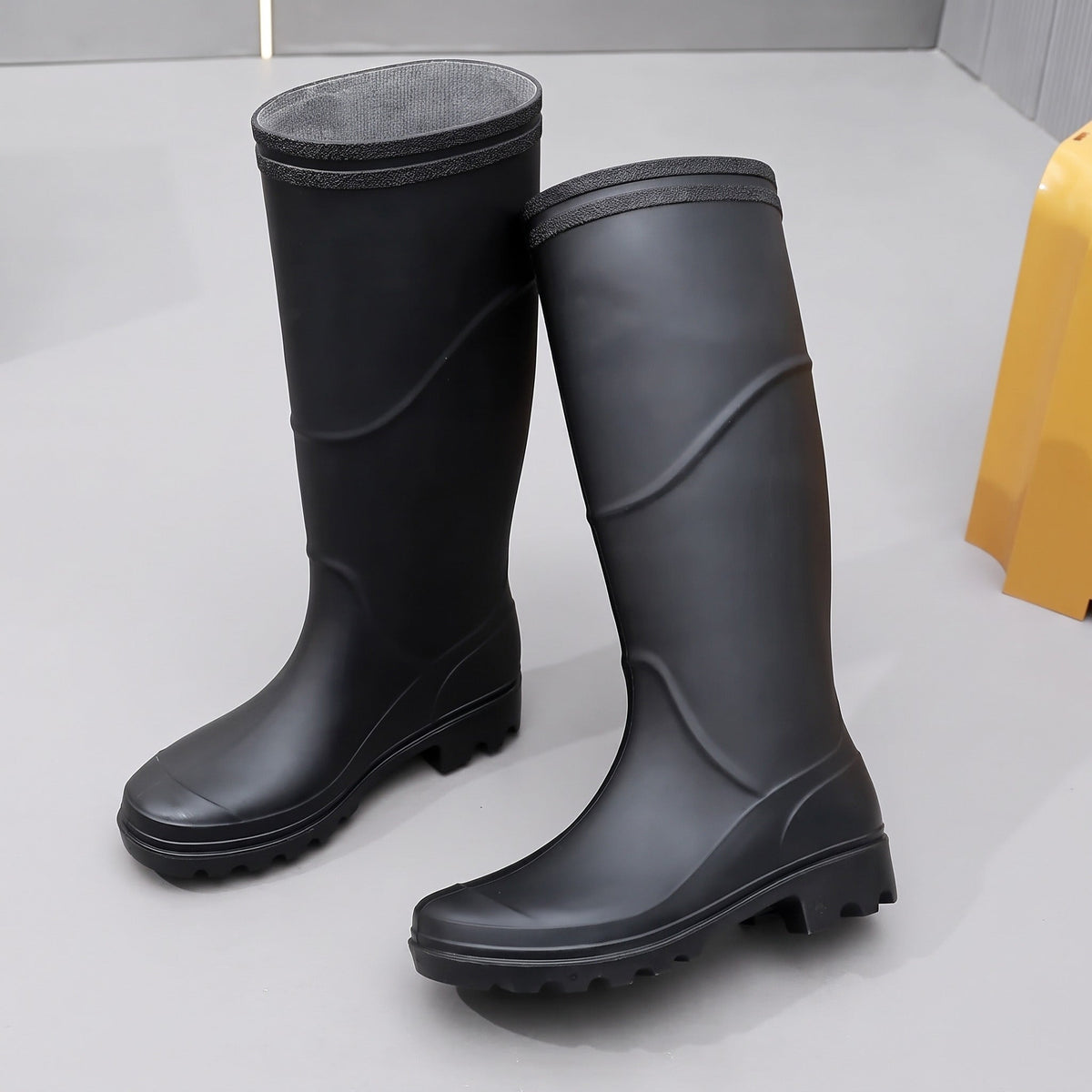 Schwarze hohe Gummistiefel, freistehend präsentiert, mit profilierter Sohle | Chaps Herrenmode