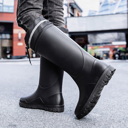 Schwarze kniehohe Gummistiefel mit Profilsohle, getragen von einer Person auf Straße | Chaps Herrenmode