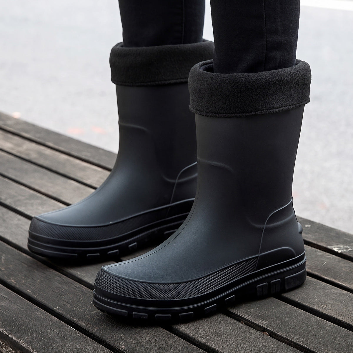 Schwarze Gummistiefel mit Fleecestulpe, getragen von einer Person auf Holzsteg | Chaps Herrenmode