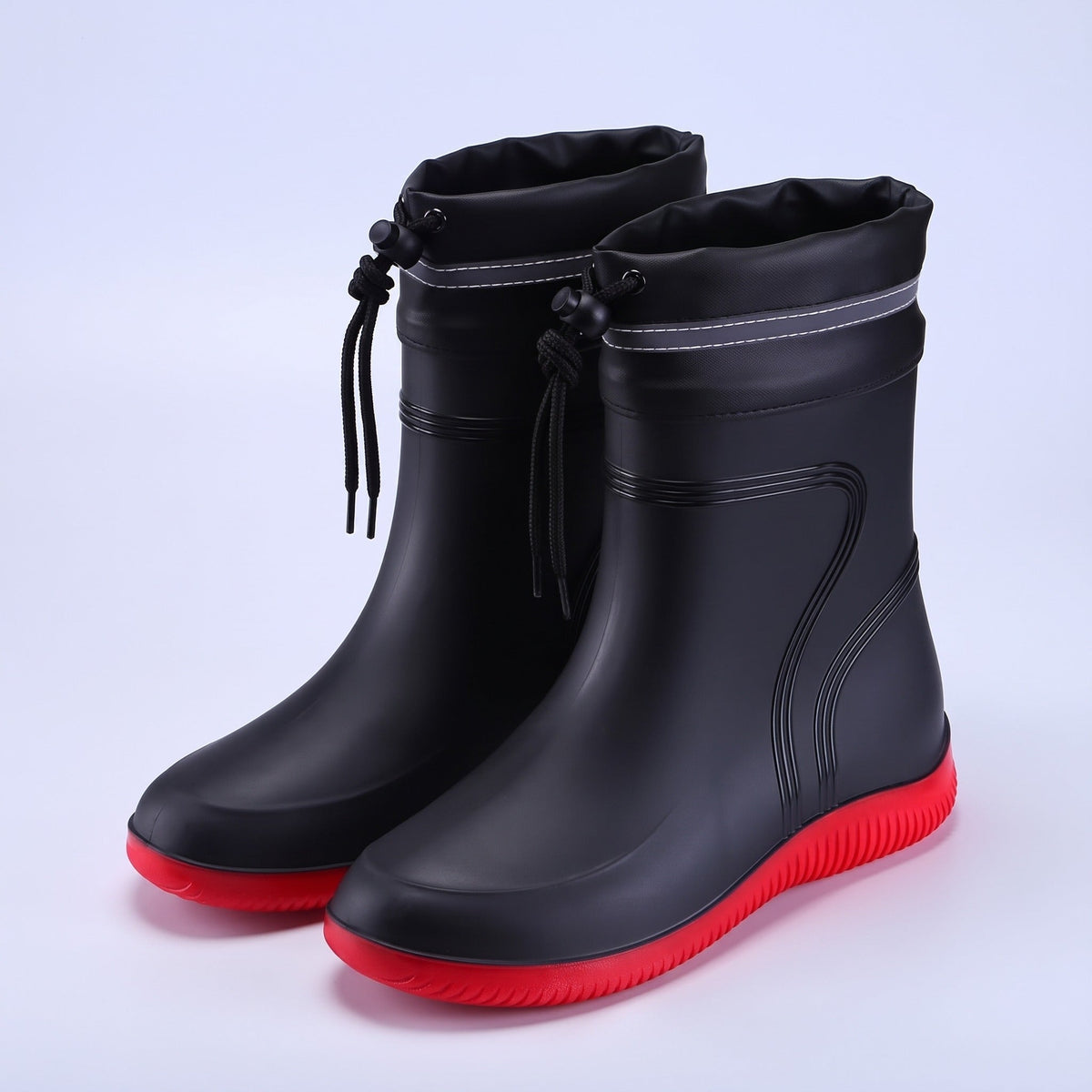 Schwarze Gummistiefel mit rotem Sohlenprofil und Kordelzug, freigestellt fotografiert | Chaps Herrenmode