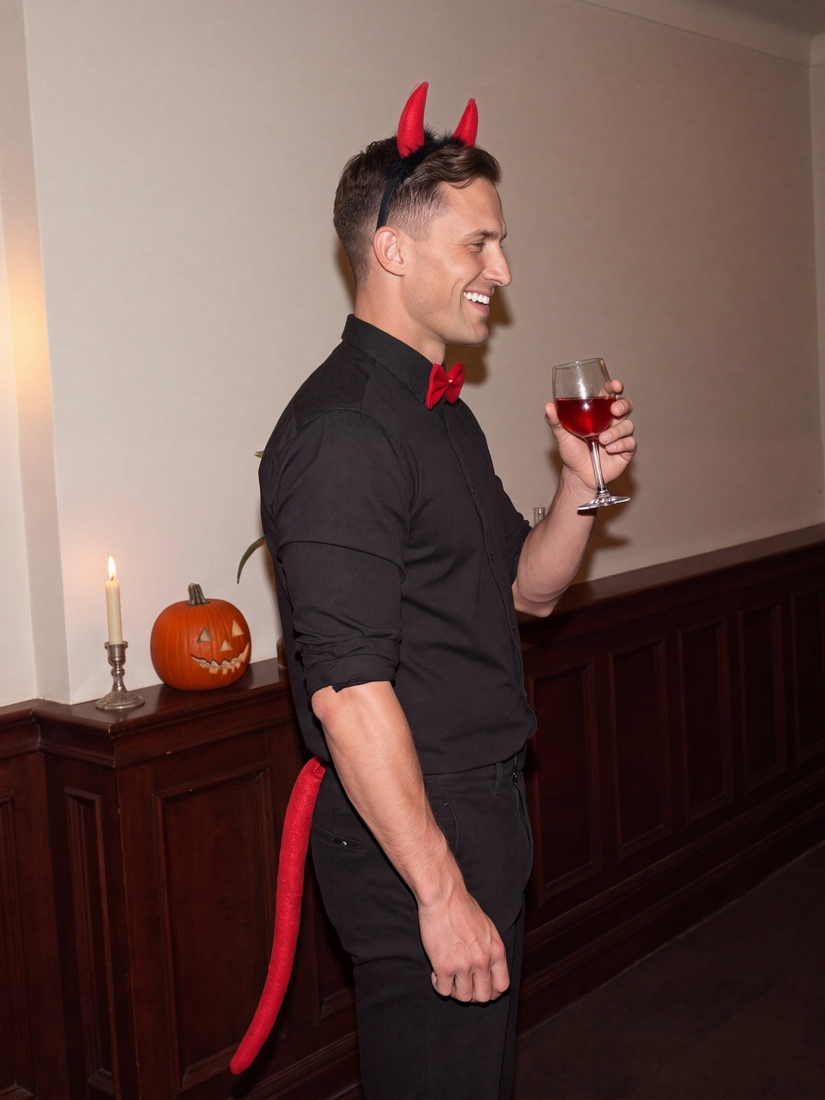 Model im Teufel-Set mit Glas auf einer Halloweenparty