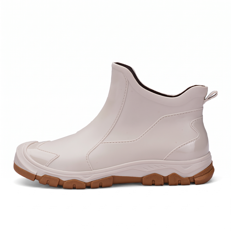 A side view of a beige rubber ankle boot with a brown lugged sole, no person present.