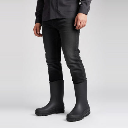 Schwarze halbhohe Gummistiefel, getragen von Person in schwarzer Jeans, Seitenansicht | Chaps Herrenmode