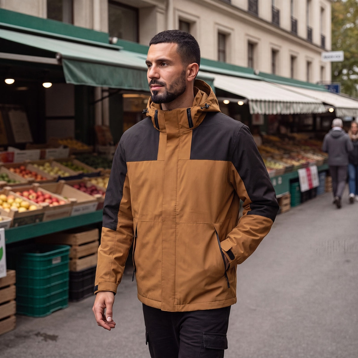 Mann trägt die camel-schwarze Regenjacke im Colour-Block-Look