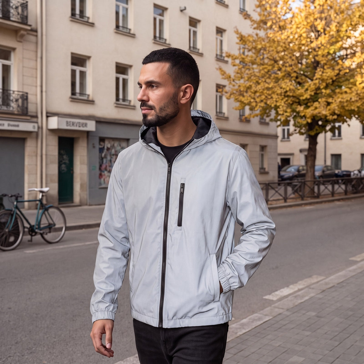 Mann trägt die silbergraue reflektierende Regenjacke