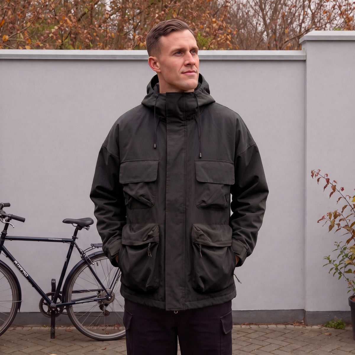 Model trägt die schwarze Utility-Regenjacke