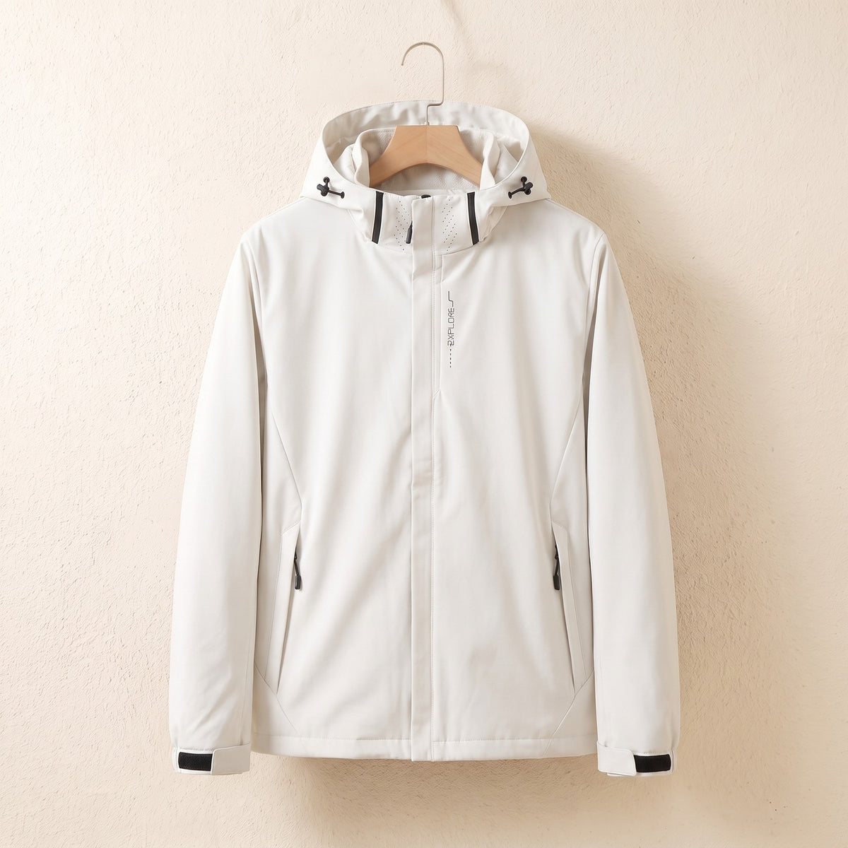 Weiße wasserdichte Jacke mit Kapuze auf dem Bügel
