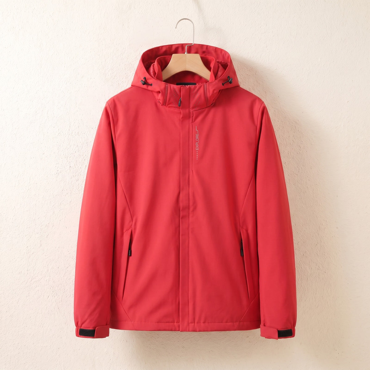 Rote wasserdichte Jacke mit Kapuze auf dem Bügel