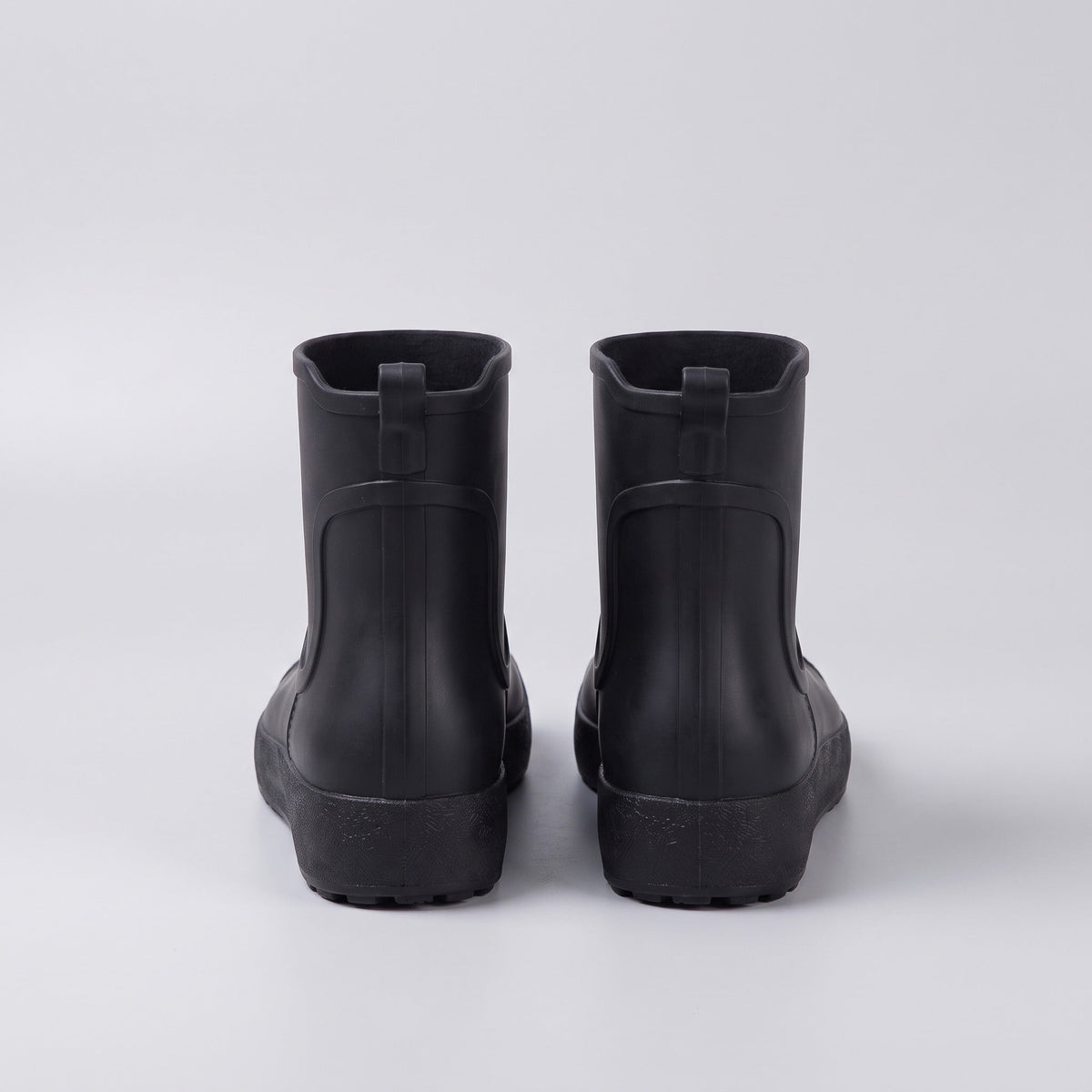 Schwarze Gummistiefel Paar von hinten fotografiert, freigestellt auf hellgrauem Hintergrund | Chaps Herrenmode