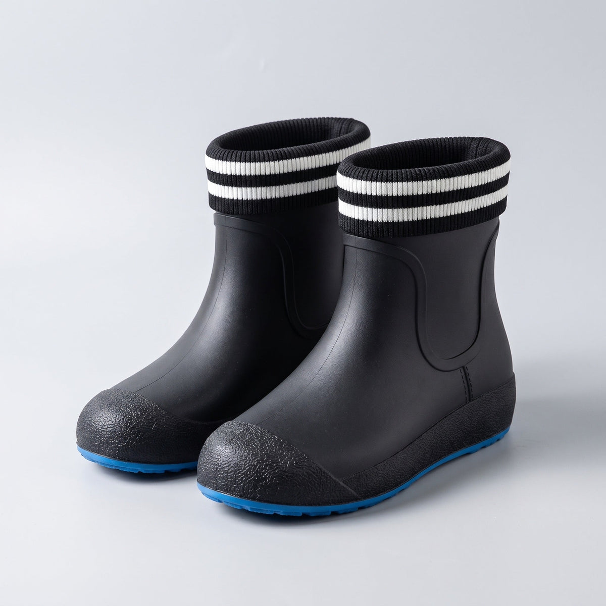 Schwarze Gummistiefel mit gestreiftem Schaft und blauer Sohle, freigestellt | Chaps Herrenmode