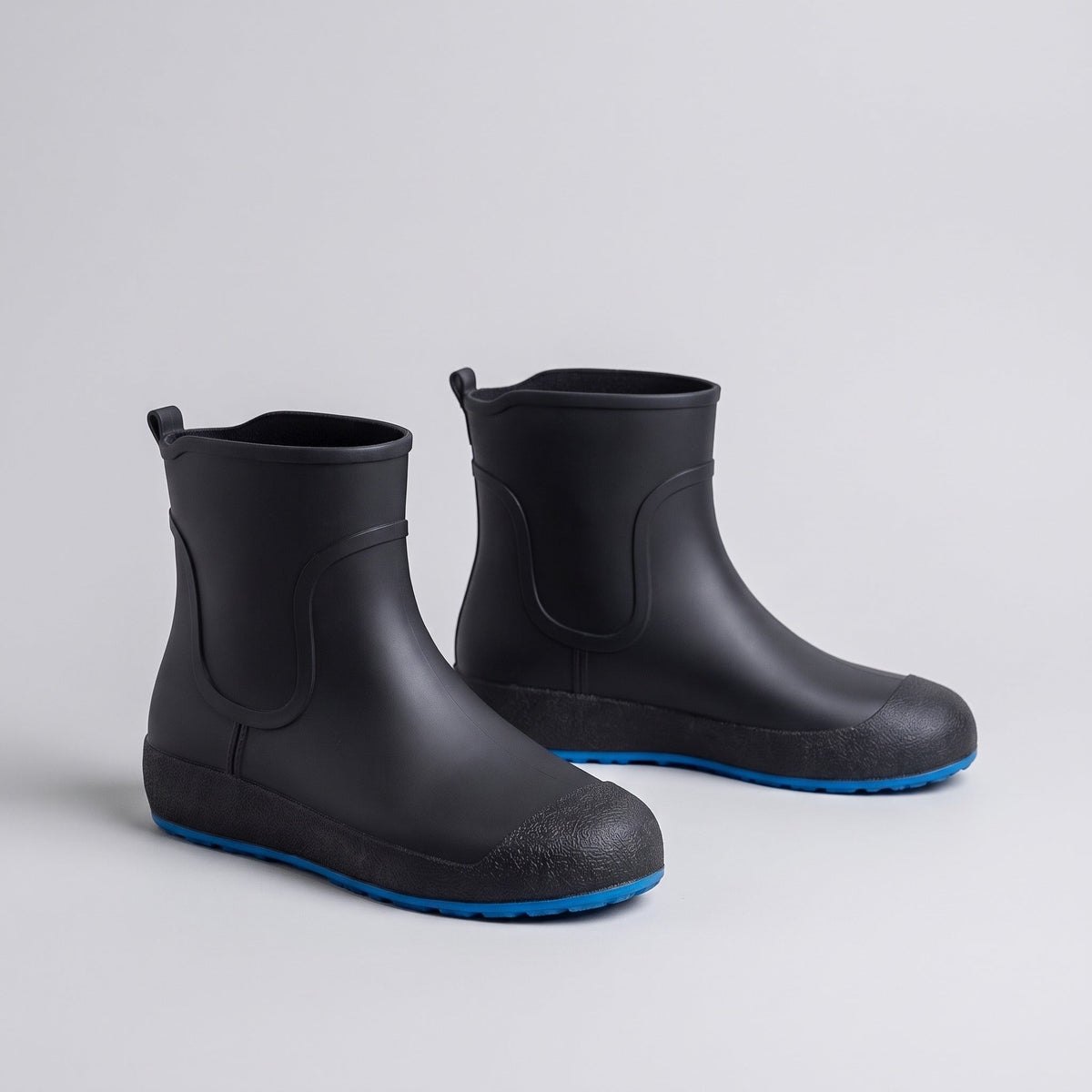 Schwarze kurze Gummistiefel mit blauer Sohle, freigestellt ohne Person | Chaps Herrenmode