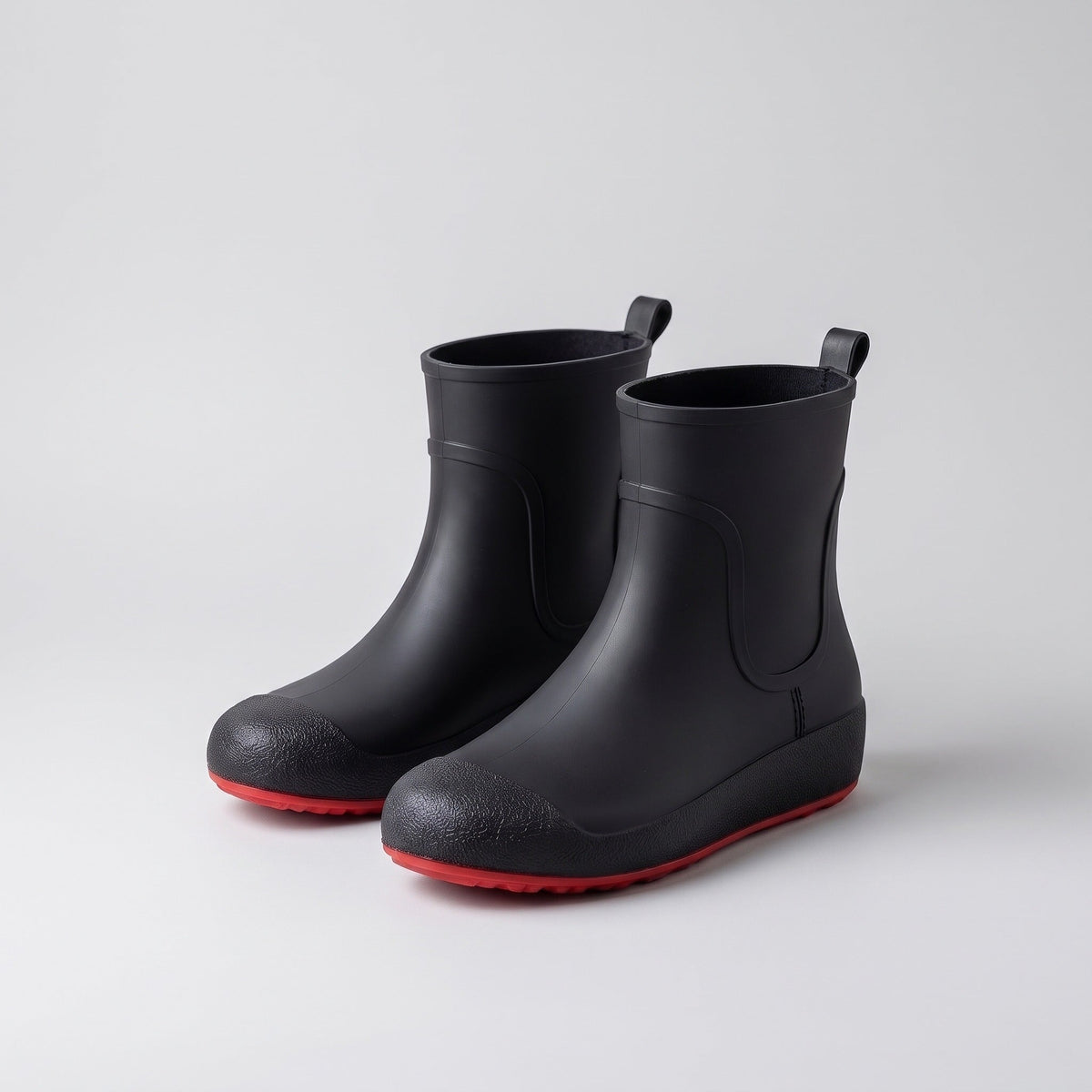 Schwarze kurze Gummistiefel mit roter Sohle, freigestellt ohne Person | Chaps Herrenmode